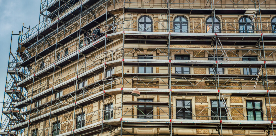 Modular scaffolding system with Comfodeck boards installed on a building facade, suitable for frame and ringlock applications
