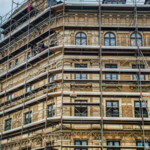 Modular scaffolding system with Comfodeck boards installed on a building facade, suitable for frame and ringlock applications