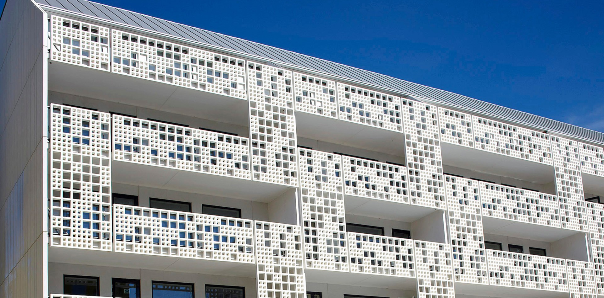 Helsinki Die vorgelagerte Fassade aus strahlendem Weiß dient als raffinierter Sichtschutz und bietet durch die Perforierung eine hohe Transparenz.