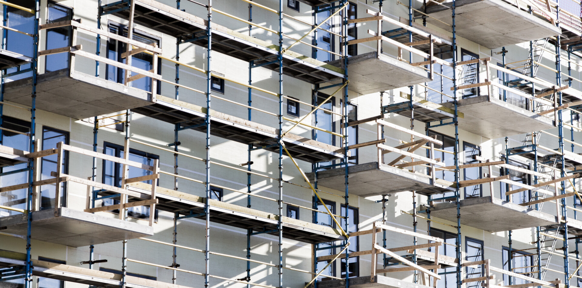 Scaffolding structure on a building facade with Comfodeck powered by alkus® plastic panels used as working platforms