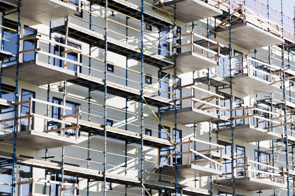 Scaffolding structure on a building facade with Comfodeck powered by alkus® plastic panels used as working platforms